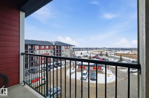 Private balcony with black metal railing, red horizontal siding, and concrete flooring - 424 1510 Watt Drive, Edmonton, AB 