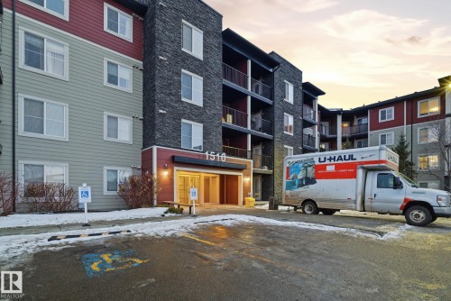 Multi-story residential building featuring a stone facade and red and green siding - 424 1510 Watt Drive, Edmonton, AB 