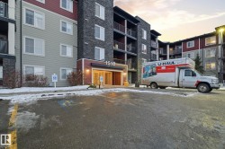 Multi-story residential building featuring a stone facade and horizontal siding - 