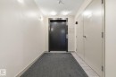 Elevator access featuring a dark finished door, neutral wall tones, and recessed lighting - 424 1510 Watt Drive, Edmonton, AB 