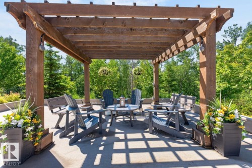 Expansive outdoor patio featuring a wooden pergola with integrated lighting - 207 5025 Edgemont Boulevard, Edmonton, AB 