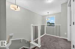 Upper landing with neutral carpeting and light gray wall paint - 