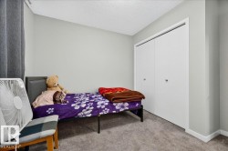 Neutral gray walls complement the textured gray carpeting in this room featuring white bi-fold closet doors and white baseboards - 