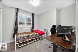 Bright room featuring neutral wall paint, a double window with horizontal blinds and dark drapery, and textured carpeting - 