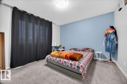 Room featuring textured carpeting and a painted accent wall - 