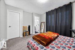 Carpeted room featuring light gray walls, a white door with a contemporary handle, and a textured ceiling - 