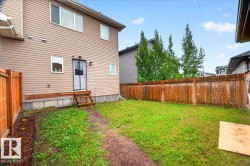 Rear exterior featuring tan horizontal siding and multiple windows - 