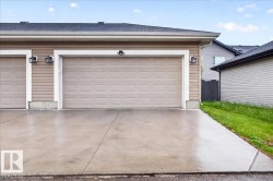 Two-car garage with panel-style doors and exterior lighting fixtures - 