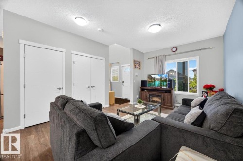 Open-concept living area featuring wood-finish flooring, recessed lighting, and a prominent window - 1187 Cy Becker Road, Edmonton, AB 