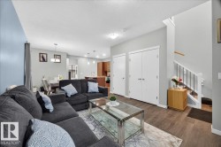 Open-concept living area featuring wood-finish flooring and light gray wall paint - 