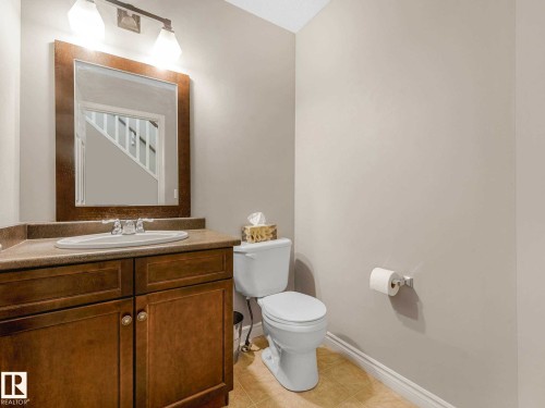 Vanity with wood-finish cabinetry, integrated sink, and laminate countertop - 1325 Latta Crescent, Edmonton, AB - Indoor Photo Showing Bathroom