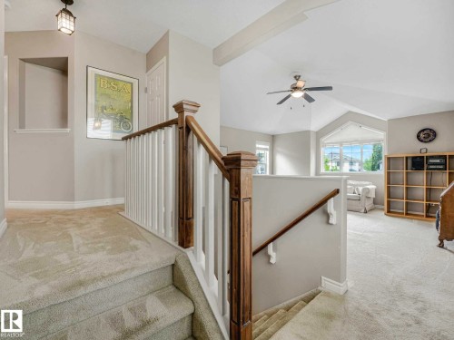 Carpeted staircase with white balusters and wood-finish newel posts and handrails - 1325 Latta Crescent, Edmonton, AB - Indoor Photo Showing Other Room