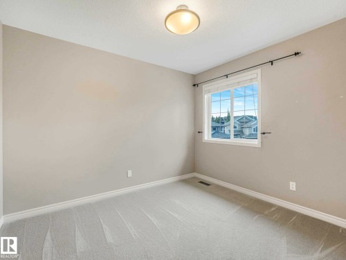 Spacious room featuring neutral wall paint, light-colored carpeting, a window with white trim, and a ceiling-mounted light fixture - 1325 Latta Crescent, Edmonton, AB - Indoor Photo Showing Other Room