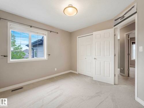 Neutral-toned room with plush carpeting, featuring a double-paned window, white trim, and a flush mount ceiling light - 1325 Latta Crescent, Edmonton, AB - Indoor Photo Showing Other Room
