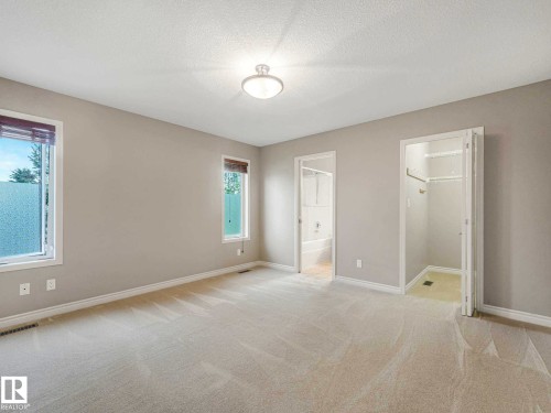 Spacious room featuring neutral carpeting, light-toned walls, and white baseboards - 1325 Latta Crescent, Edmonton, AB - Indoor Photo Showing Other Room