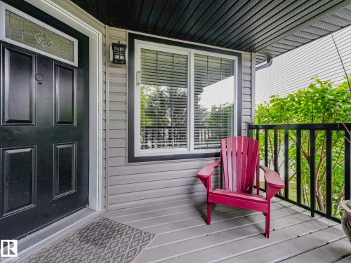 Front entry featuring a paneled door with decorative glass transom, exterior wall lantern, and horizontal siding - 1325 Latta Crescent, Edmonton, AB - Outdoor With Deck Patio Veranda With Exterior