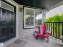 Front entry featuring a paneled door with decorative glass transom, exterior wall lantern, and horizontal siding - 1325 Latta Crescent, Edmonton, AB  - Outdoor With Deck Patio Veranda With Exterior 