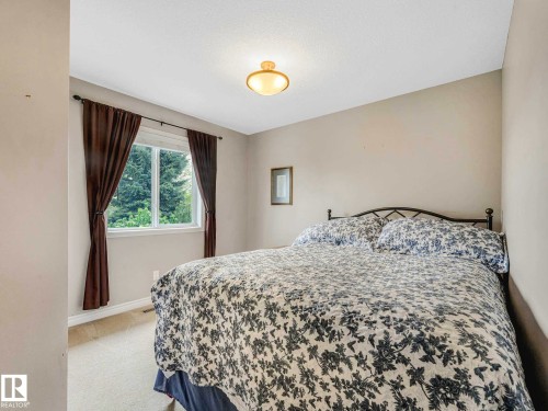 Neutral wall finishes with a window offering natural light, complemented by a ceiling-mounted light fixture - 1325 Latta Crescent, Edmonton, AB - Indoor Photo Showing Bedroom