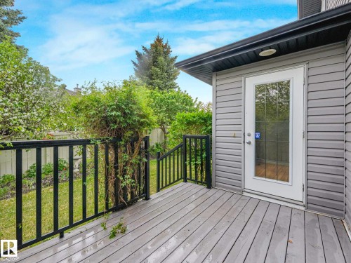 Outdoor deck with wood-finish flooring, black metal railings, and a glass-paneled exterior door - 1325 Latta Crescent, Edmonton, AB - Outdoor With Deck Patio Veranda With Exterior