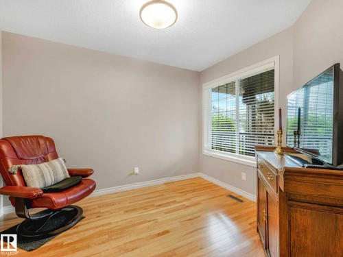 Room featuring light wood-finish flooring, a white trim baseboard, and a large window with white blinds - 1325 Latta Crescent, Edmonton, AB - Indoor