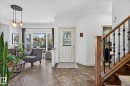 Entryway featuring an ornate glass-paneled door, tile flooring, and a wood staircase with decorative iron spindles - 163 Galland Crescent, Edmonton, AB 