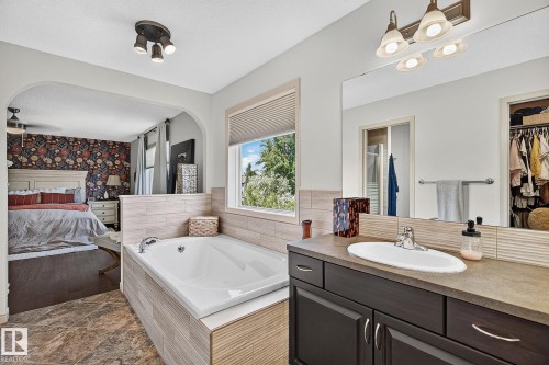 Built-in soaking tub with light wood-look tile surround and window - 163 Galland Crescent, Edmonton, AB 