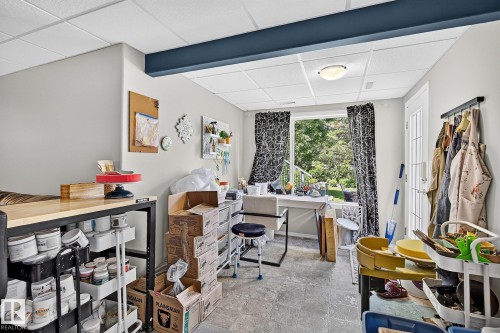 Bright lower-level room featuring a full-light exterior door, a large window, drop ceiling, recessed lighting, and durable flooring - 163 Galland Crescent, Edmonton, AB 