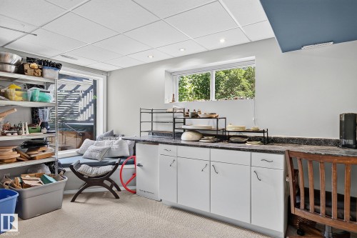 Lower level room featuring a built-in window seat, ample counter space with white cabinetry, recessed lighting, and a large window providing natural illumination - 163 Galland Crescent, Edmonton, AB 