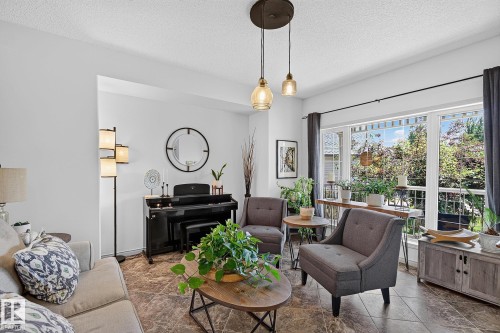Spacious living area featuring large windows, durable tile flooring, and recessed ceiling lights - 163 Galland Crescent, Edmonton, AB 