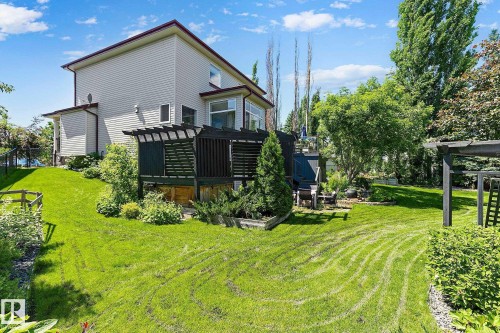 Manicured lawn with a terraced landscape leading to a multi-level deck - 163 Galland Crescent, Edmonton, AB 