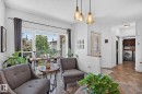 Living area with large picture windows and multiple pendant light fixtures - 163 Galland Crescent, Edmonton, AB 