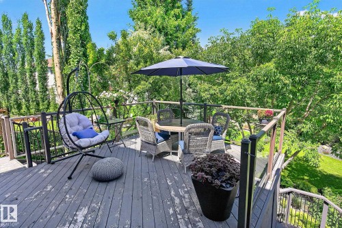 Spacious multi-level deck featuring wood-finish decking and dark-toned railings with glass panel inserts - 163 Galland Crescent, Edmonton, AB 
