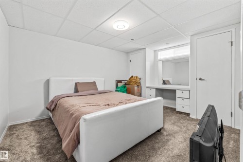 Carpeted room featuring a built-in desk with integrated storage drawers - 10130 62 Street, Edmonton, AB - Indoor Photo Showing Bedroom