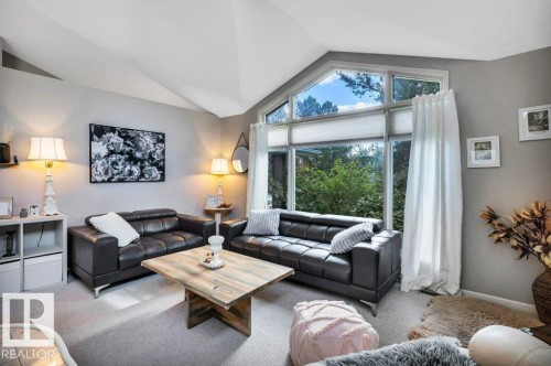 Living area featuring vaulted ceilings and a large window wall - 11742 29 Avenue, Edmonton, AB 