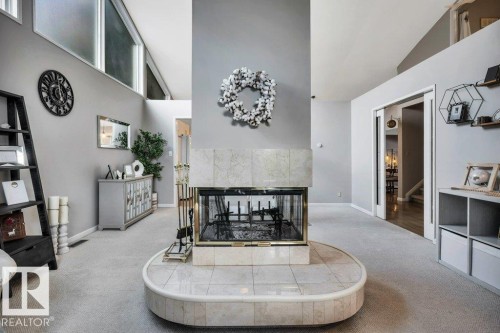 Central fireplace with a tile surround and hearth, featuring a golden-toned firebox - 11742 29 Avenue, Edmonton, AB 