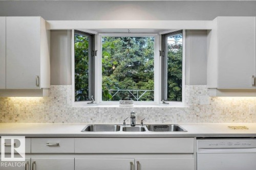 Kitchen sink with dual basins and a single-handle faucet, set within a light-toned countertop - 11742 29 Avenue, Edmonton, AB 