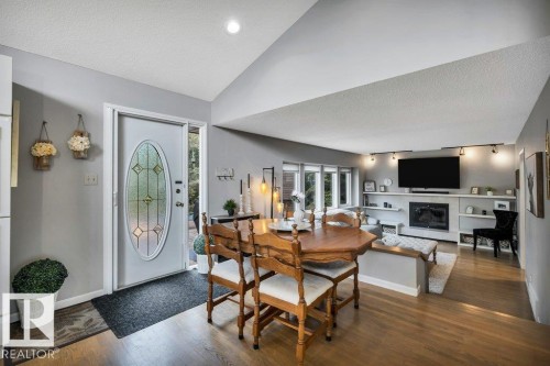 Entry area featuring a decorative front door with an oval glass insert, wood-finish flooring, and a recessed ceiling light - 11742 29 Avenue, Edmonton, AB 