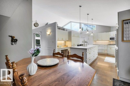 Open-concept kitchen with vaulted ceilings, transom windows, and wood-finish flooring - 11742 29 Avenue, Edmonton, AB 