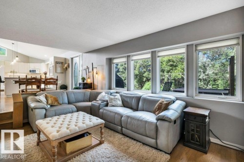 Living area featuring wood-finish flooring and a series of windows providing exterior views - 11742 29 Avenue, Edmonton, AB 