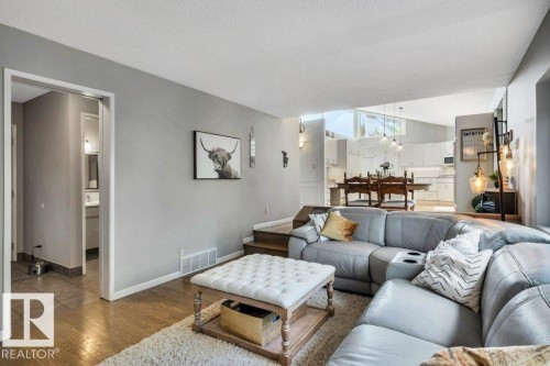 Open-concept living space featuring wood-finish flooring, a neutral color palette, and a split-level design - 11742 29 Avenue, Edmonton, AB 