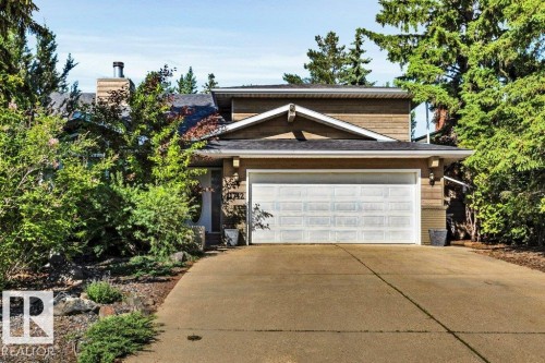 Front elevation featuring a two-car garage, mature landscaping, and an asphalt shingle roof - 11742 29 Avenue, Edmonton, AB 