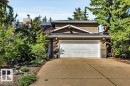Front elevation featuring a two-car garage, mature landscaping, and an asphalt shingle roof - 11742 29 Avenue, Edmonton, AB 