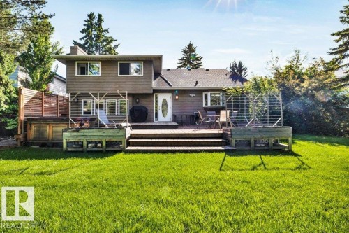 Expansive green lawn with a two-level wood deck and integrated planters - 11742 29 Avenue, Edmonton, AB 