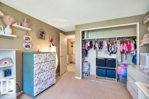 Spacious room featuring neutral-toned walls, plush carpeting, and a built-in closet with ample storage - 11742 29 Avenue, Edmonton, AB 