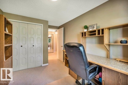 Built-in wood-finish shelving and desk unit with integrated storage, neutral wall color, and light-toned carpet flooring - 11742 29 Avenue, Edmonton, AB 