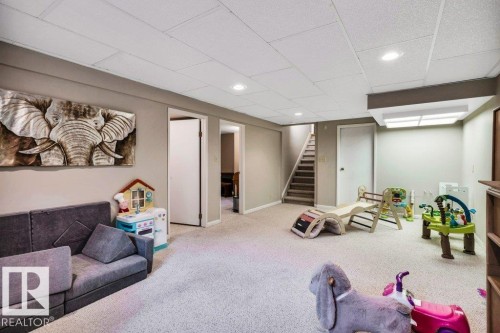 Spacious lower level featuring light-colored carpeting, recessed lighting, drop ceiling, and a carpeted staircase - 11742 29 Avenue, Edmonton, AB 