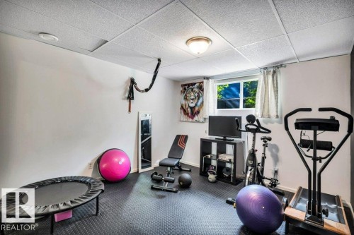 Finished room featuring recessed and flush mount lighting, a window, dark resilient flooring, and acoustic ceiling tiles - 11742 29 Avenue, Edmonton, AB 