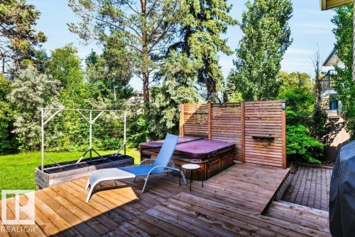 Expansive outdoor living space featuring a wood deck, built-in hot tub, and slatted privacy screens - 11742 29 Avenue, Edmonton, AB 