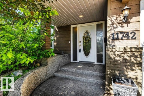 Front entry featuring a white door with an oval glass insert and sidelights - 11742 29 Avenue, Edmonton, AB 
