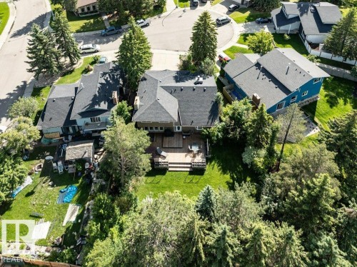 Expansive backyard featuring a multi-level wooden deck, a manicured lawn, and mature trees - 11742 29 Avenue, Edmonton, AB 